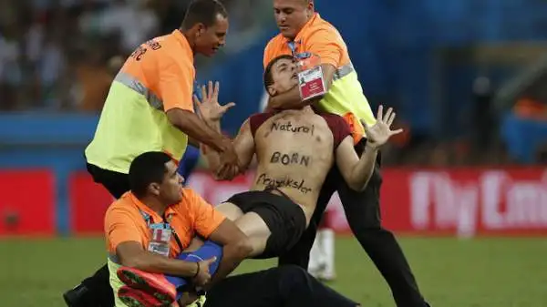 Durante i supplementari di Germania-Argentina, un 'burlone' è entrato in campo, ha baciato il terzino sinistro tedesco Höwedes ed è stato placcato. Sul petto la scritta "Mattacchione nato".