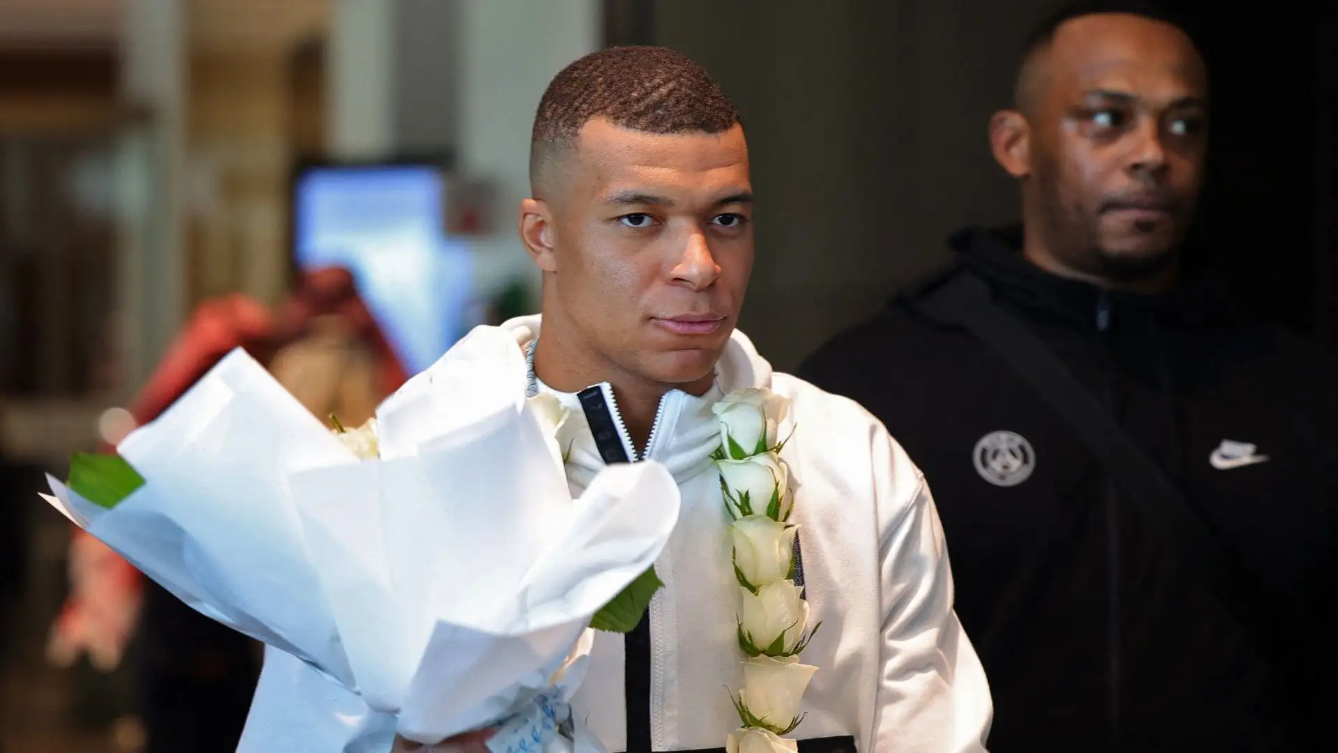 Kylian Mbappé con una collana di fiori