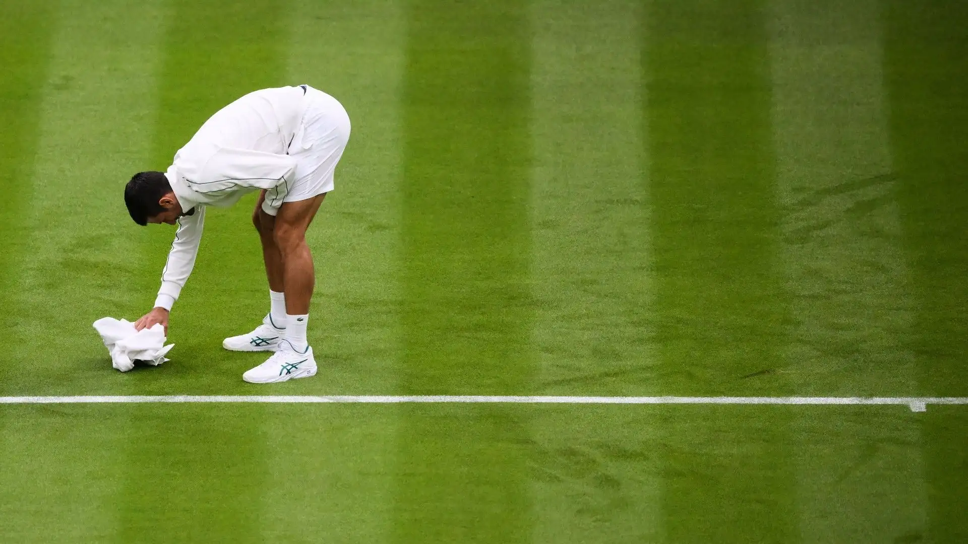 Ecco il tennista mentre cerca di asciugare il campo con la sua salvietta