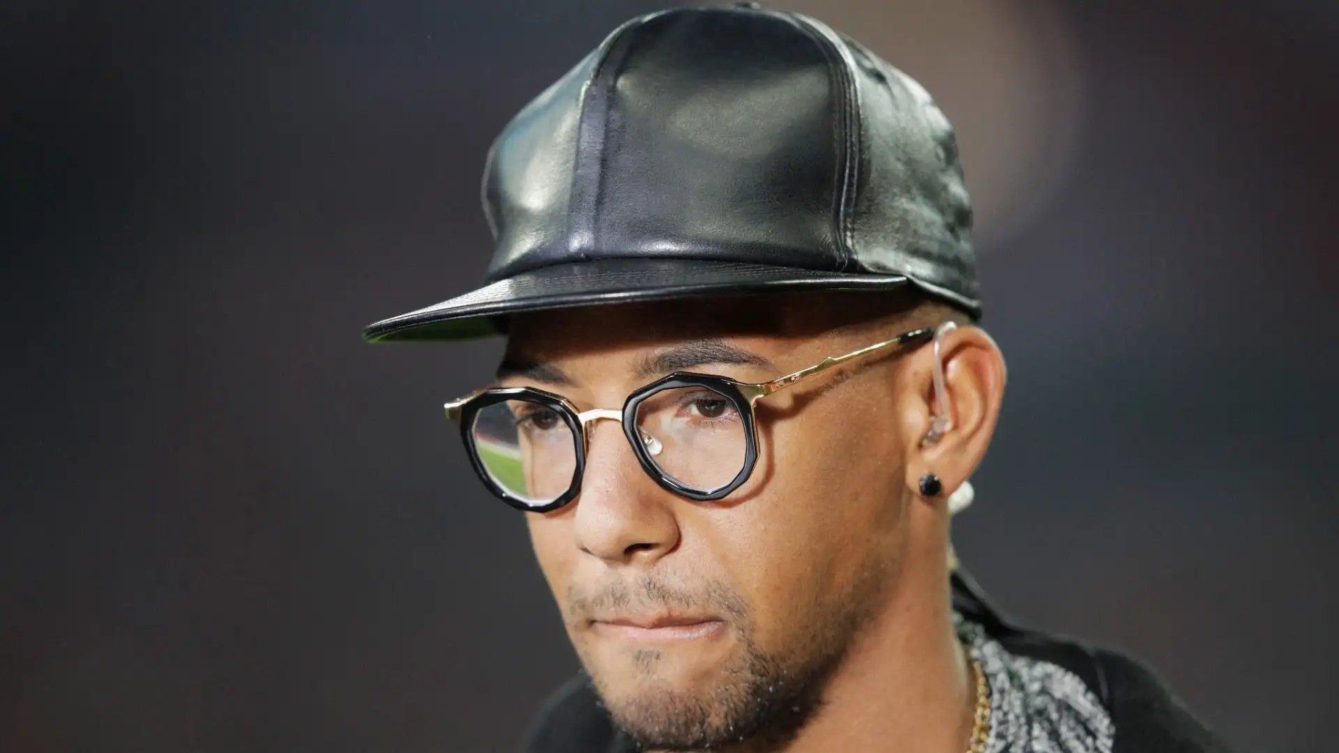 Eccolo di nuovo col vistoso cappellino nero