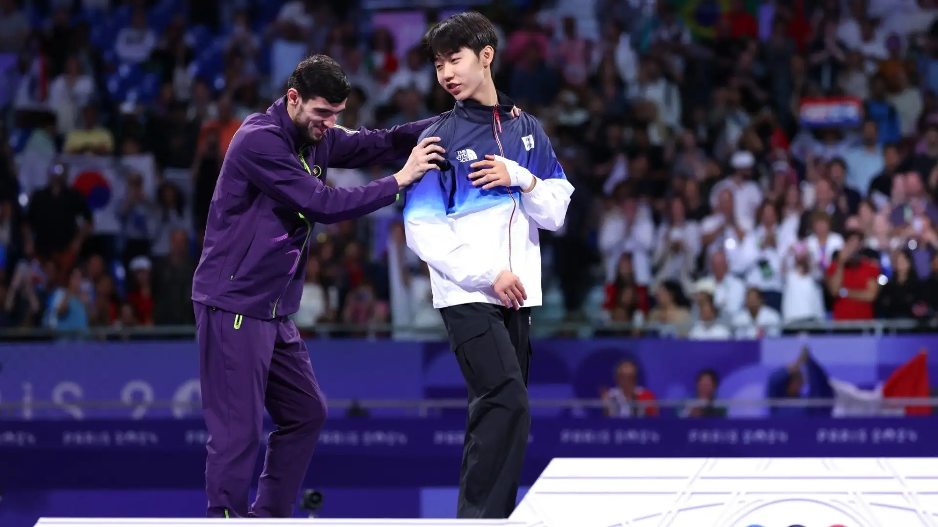 Il sudcoreano ha anche aiutato Magomedov a salire sul podio

