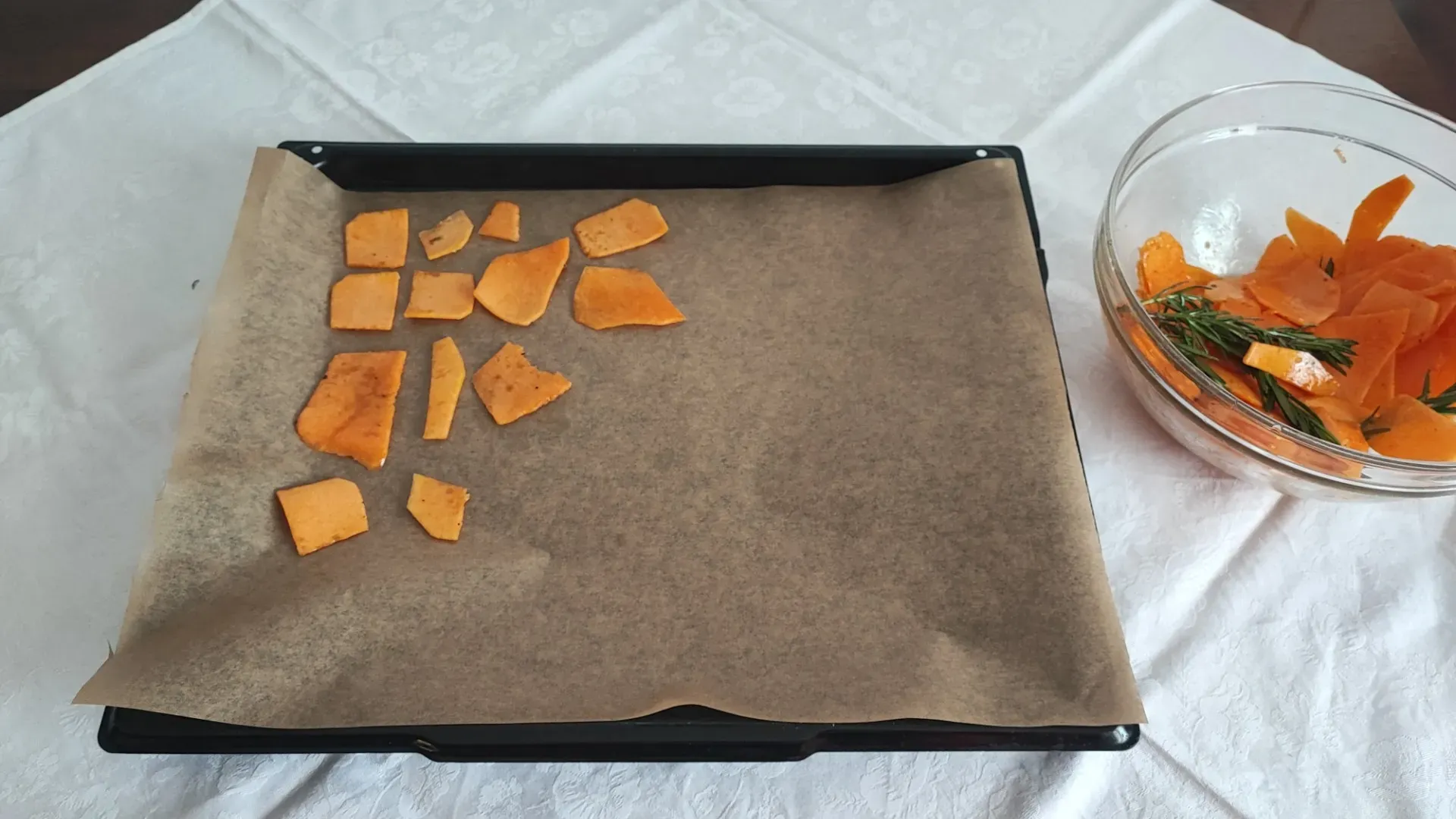 Copriamo la leccarda con un foglio di carta forno e distribuiamo le fettine di zucca facendo attenzione a non sovrapporle
