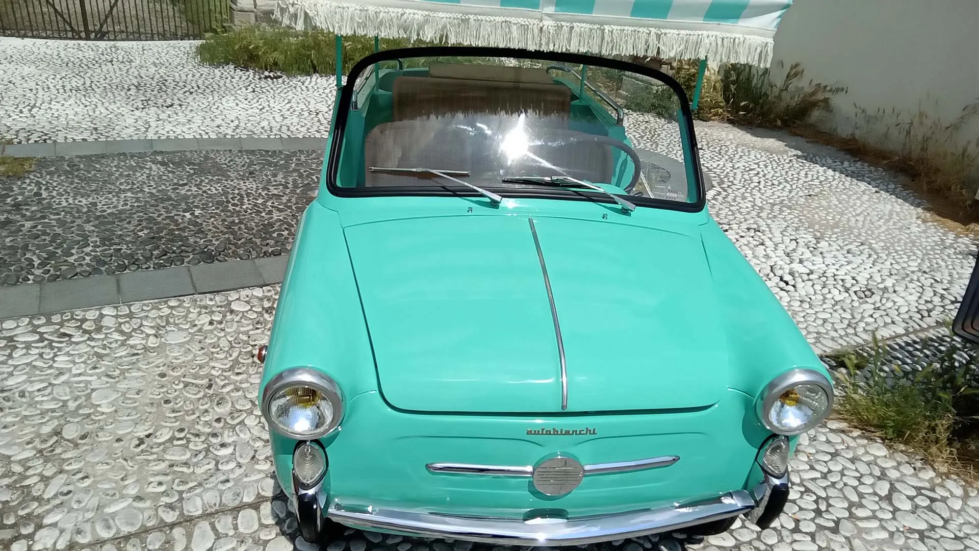 I baffi cromati e la mascherina riprendono quelli della trasformabile, segno della continuità stilistica con il resto della gamma Autobianchi