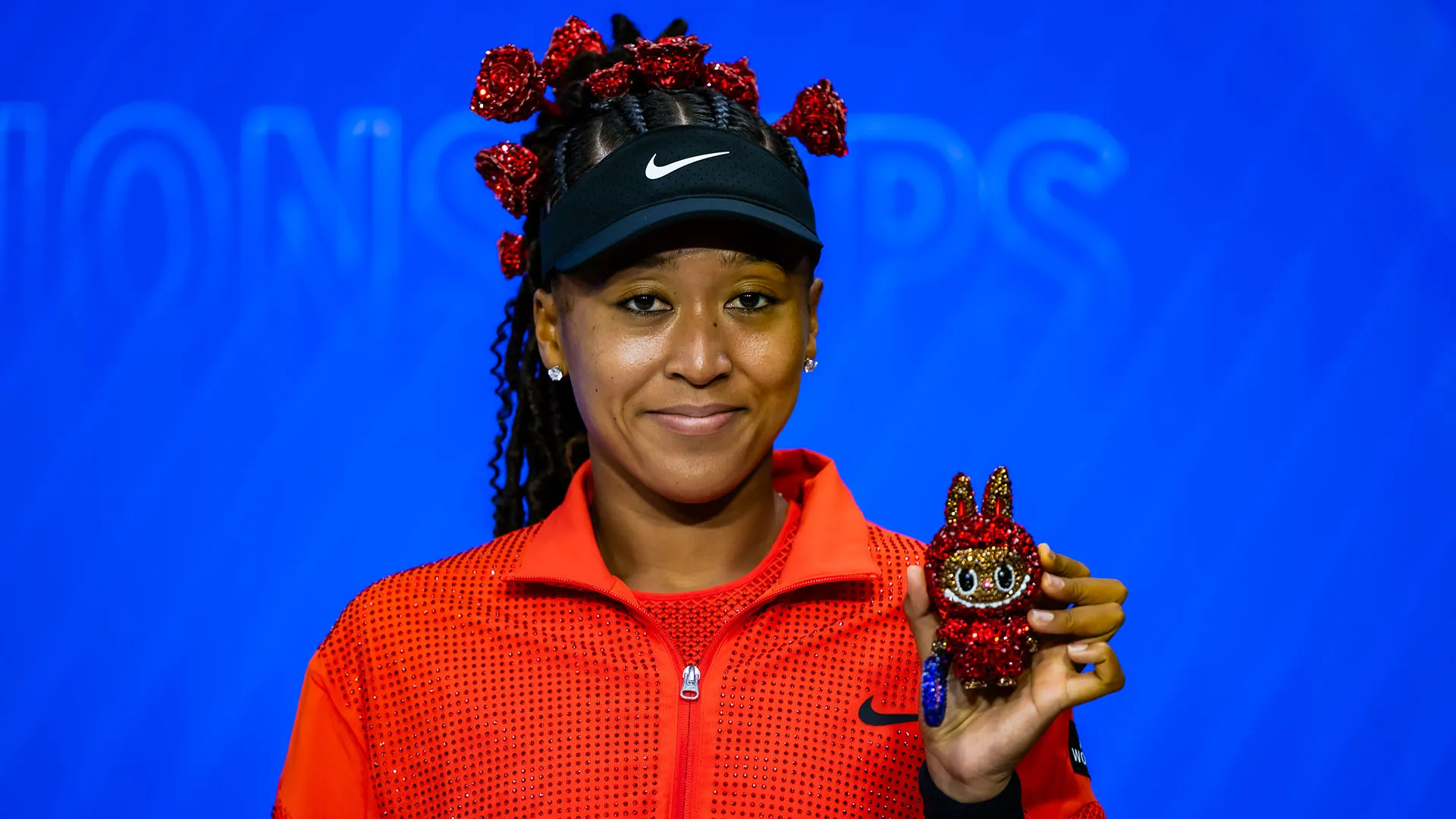 Il pupazzo è perfettamente abbinato con gli accessori in testa a Naomi Osaka