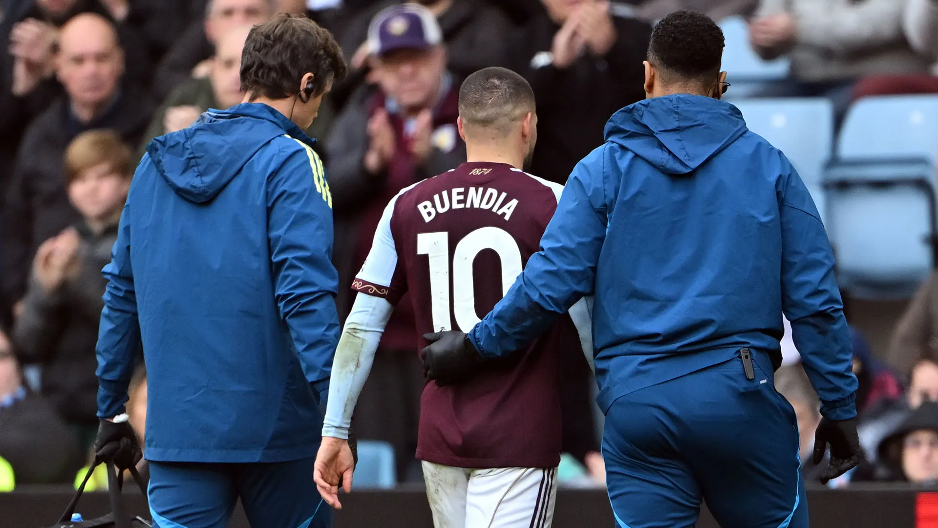 Eccolo mentre viene scortato fuori dal campo dal personale medico dell'Aston Villa