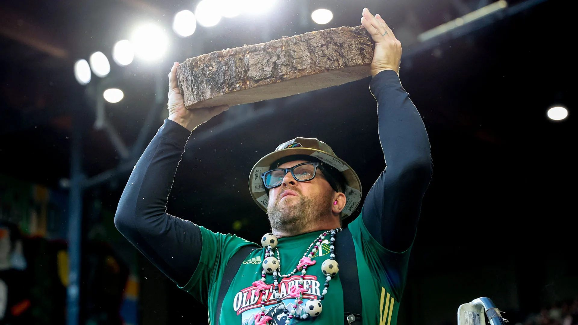 Eccolo mentre alza al cielo una sezione di legno appena tagliata